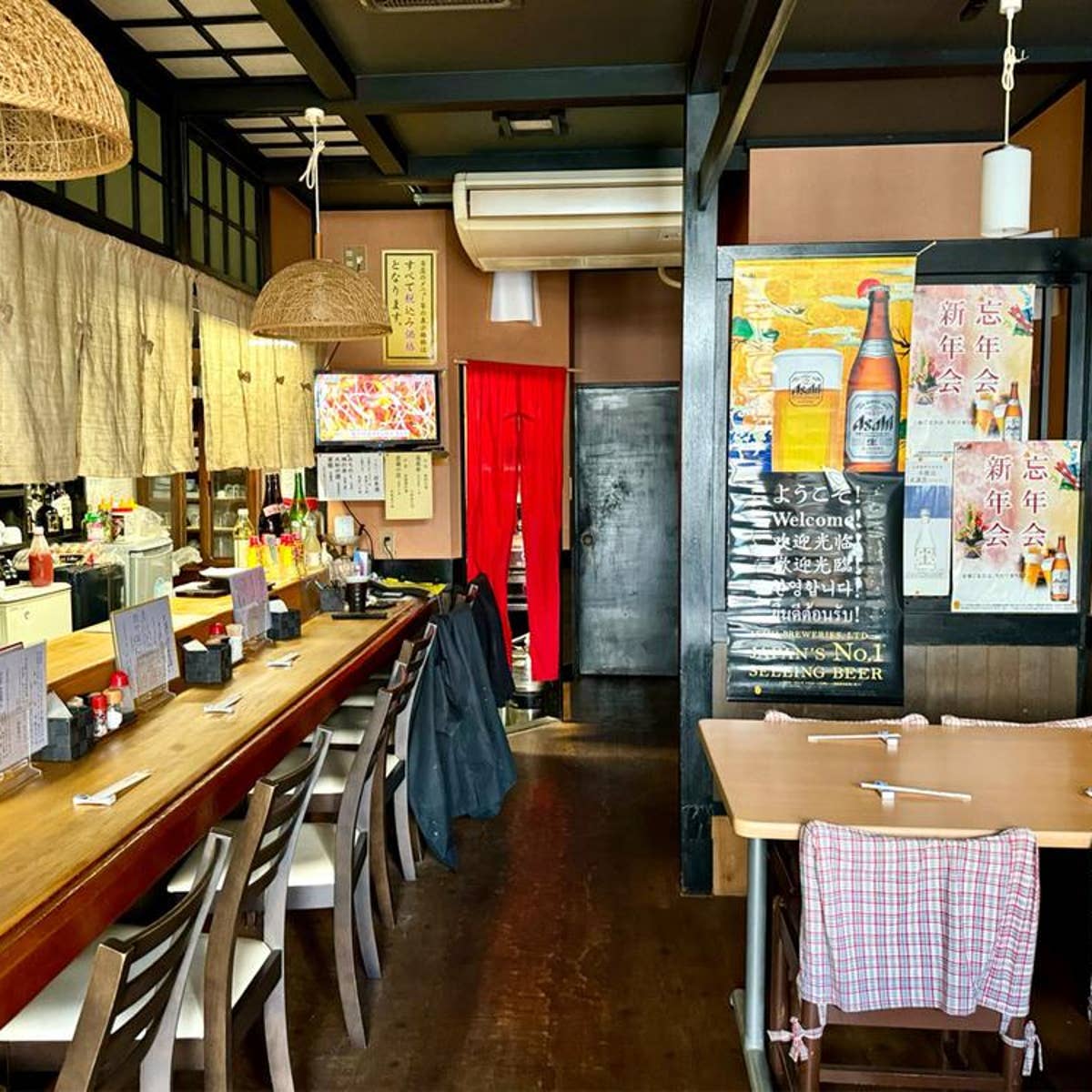 木のカウンターとテーブルが並ぶ、みやび亭の店内